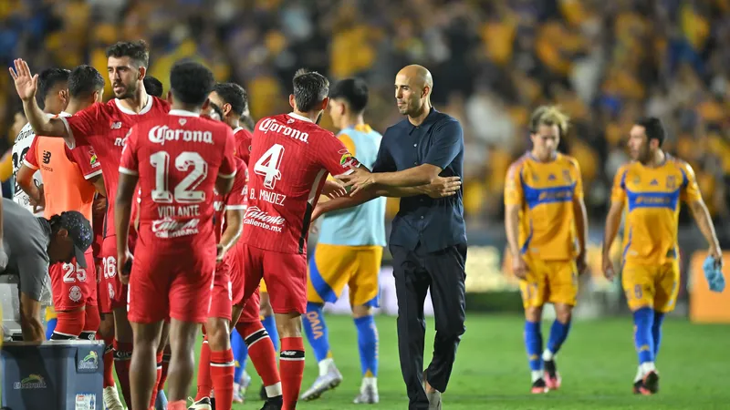 Cầu thủ Tigres UANL chạy nhanh với bóng trước sự áp đảo của hậu vệ Toluca