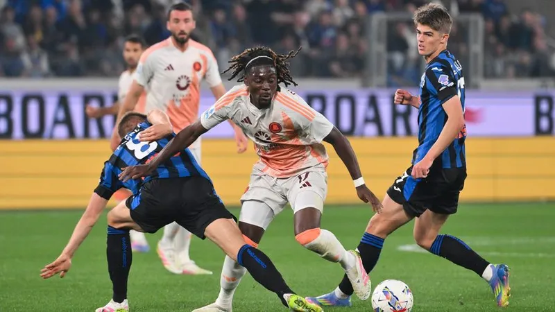 Cầu thủ AS Roma và Atalanta tranh chấp quả bóng trên sân cỏ